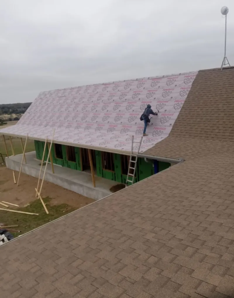 Worker preparing underlayment for a metal roof installation in Loudoun Valley Estates